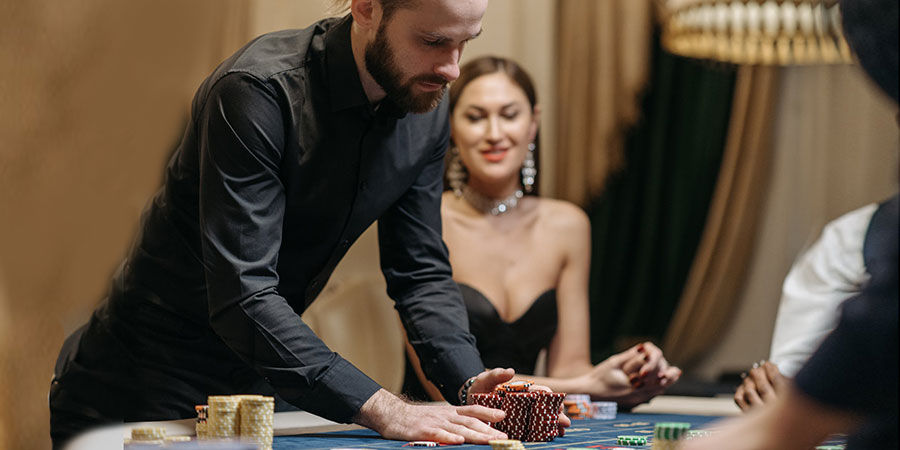 man wearing black dress shirt while betting all his casino chips beside a woman sitting on a casino table